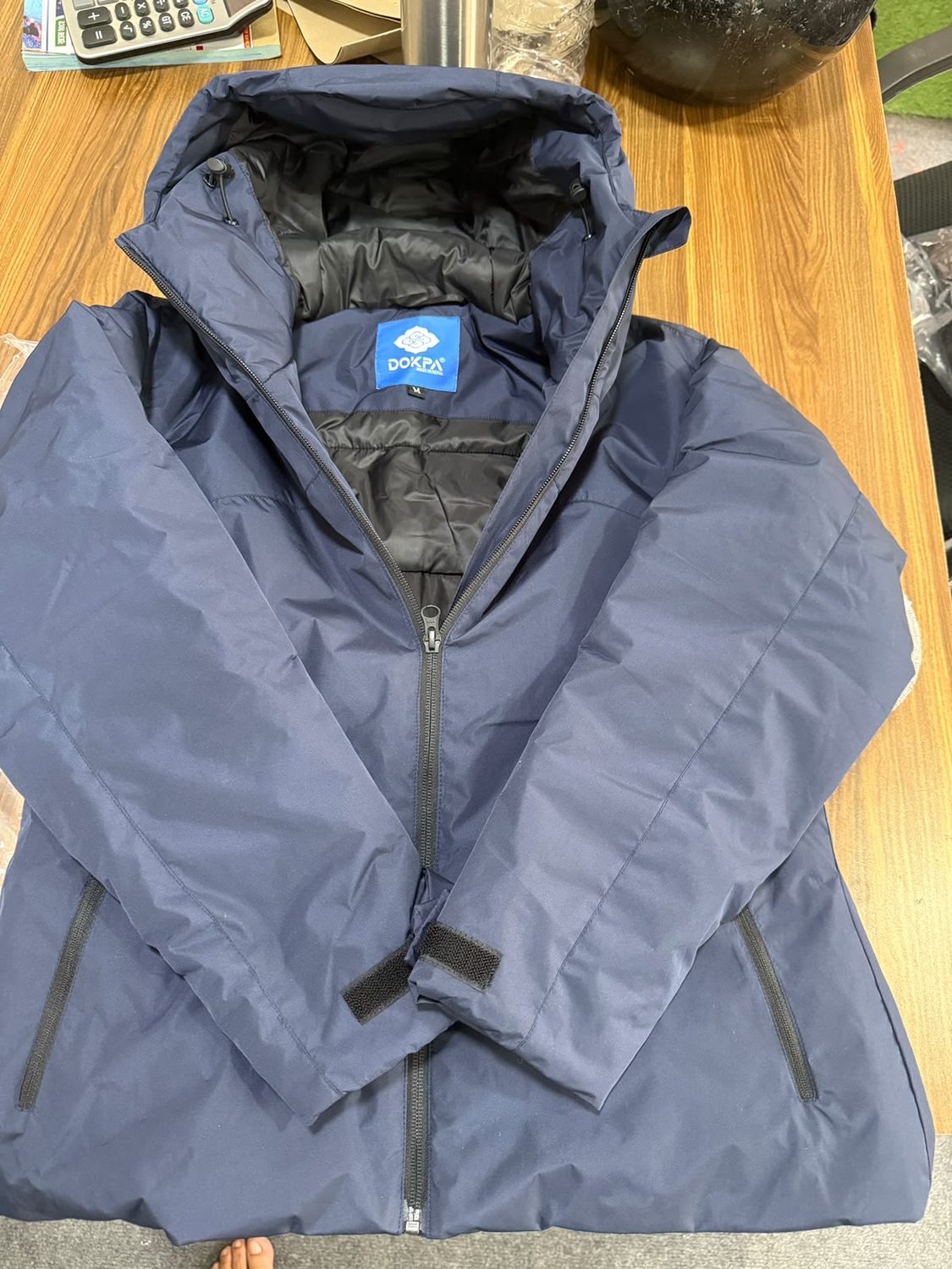 A blue grey jacket opened to show the blue Dokpa woven label at the inside collar